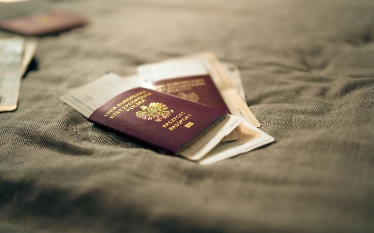 A close-up of a Polish passport and travel documents placed on a fabric surface
Image Credit: Jakub Zerdzicki/Pexels
