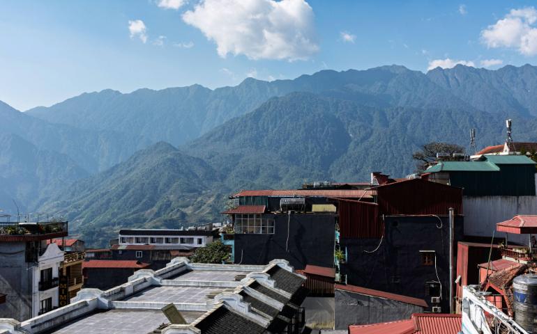 Rooftops of Sapa with dramatic mountains in the background on a clear day.
Image Credit: Kirandeep Singh Walia/Pexels