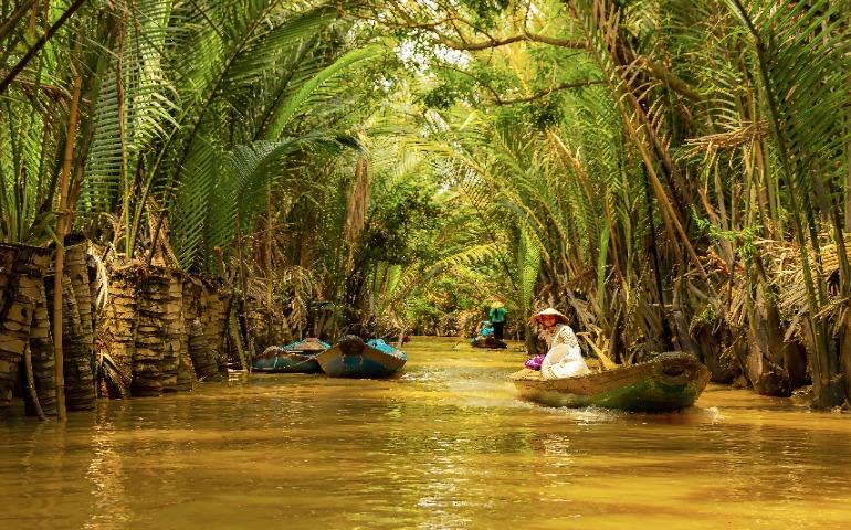 A peaceful journey down a tropical canal with boats and lush greenery.
Image Credit: Alberto Capparelli/Pexels