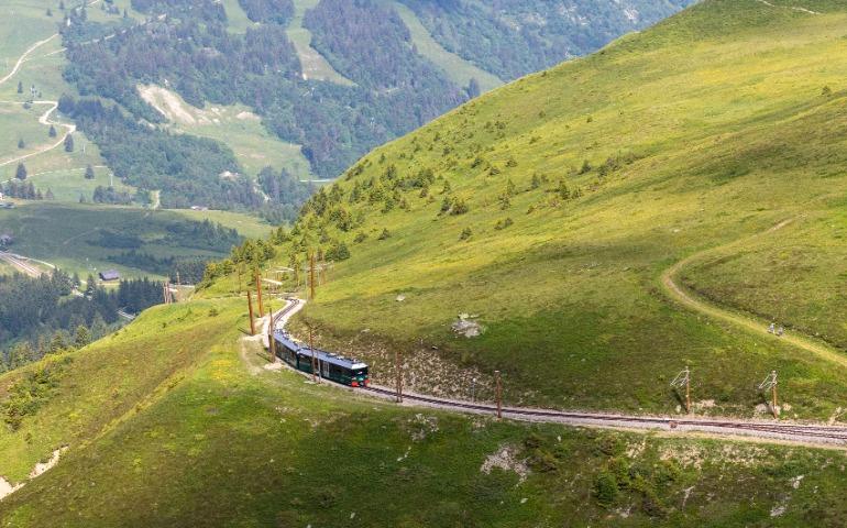 Explore scenic mountain views with a train traveling through lush green hills ( Switzerland)
Image Credit: Philippe F./Pexels 