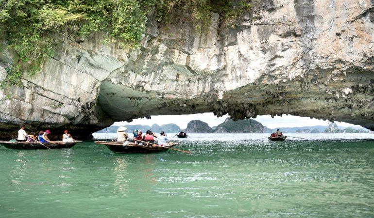 Tourists explore scenic Halong Bay in small boats under a limestone arch
Image Credit: Quang Nguyen Vinh/Pexels