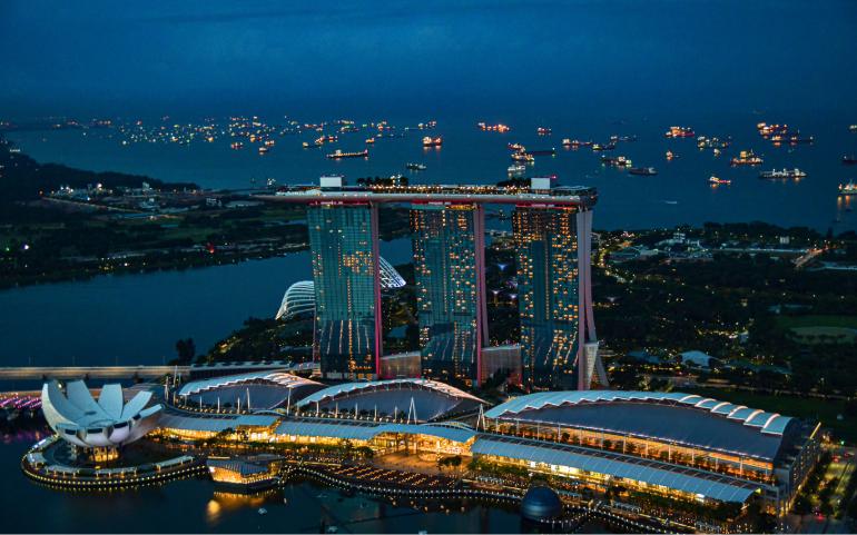Stunning aerial night view of Marina Bay Sands, Singapore with illuminated skyline and waterfront.
Image Credit: Ravish Maqsood/Pexels