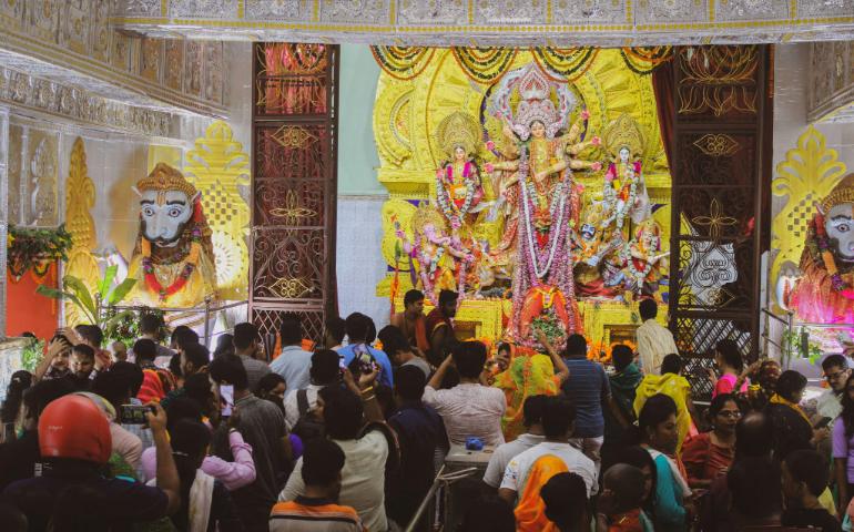 Crowd gathered for a vibrant Durga Puja celebration inside a decorated temple.
Image Credit - Stuti ...../Pexels