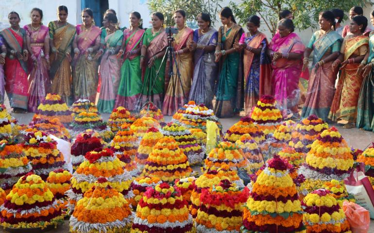 Women celebrating the Bathukamma festival with colorful flower arrangements in Telengana.
Image Credit - Telugu ItihasamTV/Pexels