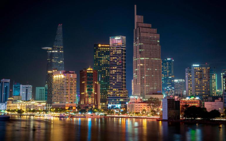 Stunning night view of the illuminated Ho Chi Minh City skyline reflecting on the water.
Image Credit: Thien Le Duy/Pexels
