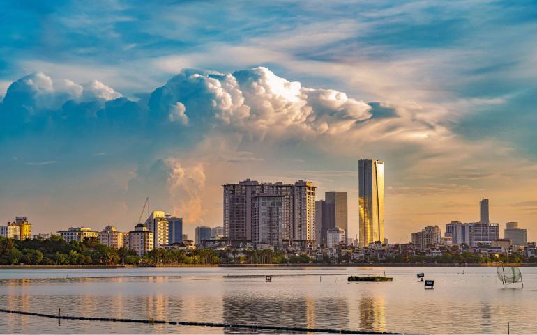 Vibrant sunset over Hanoi's skyline, reflecting beautifully on the calm river waters.
Image Credit: tu nguyen/Pexels
