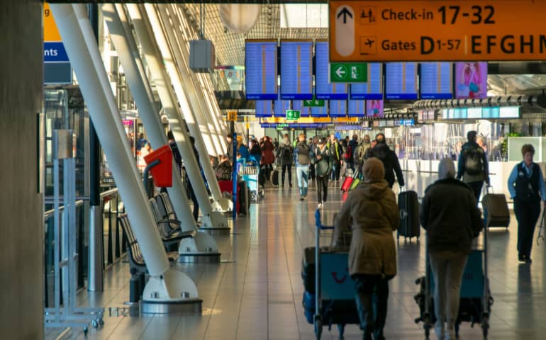 People walking in the check-in hall at Schiphol airport, Amsterdam, NL