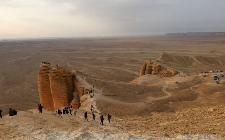 A group of people standing on the top of the desert