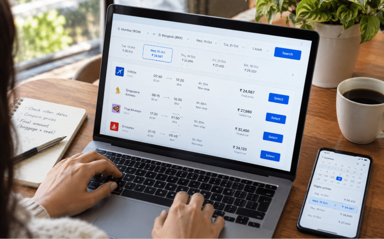A traveller checks flight prices across different dates on a laptop and phone before booking.
Image Generated: AI