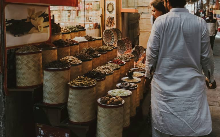 People exploring a spice stall in Dubai's traditional souq