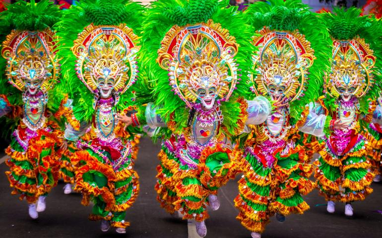 People wearing vibrant clothes and colourful masks during MassKara Festival