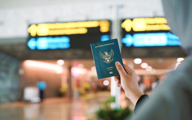 A person holding an Indonesian passport at a busy airport terminal in Yogyakarta, Indonesia.
Image Credit: Yazid N/Pexels