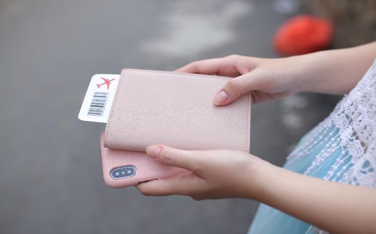 A woman holding a passport with a boarding pass
Image Credit: Thiếu Quân Võ Vũ/Pexels