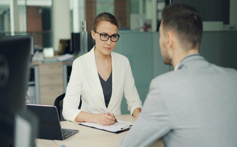 Woman in glasses and suit is interviewing a male.
Image Credit: Vitaly Gariev/Unsplash